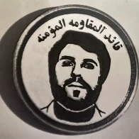 A lapel badge worn by the “Believers Resistance” with an image of Haj Zuheir Shihadi. belivers resistance