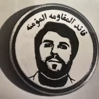 A lapel badge worn by the “Believers Resistance” with an image of Haj Zuheir Shihadi. belivers resistance